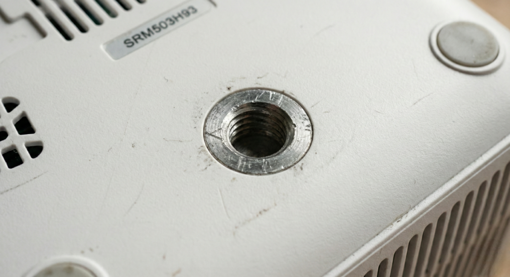 Detalhe da rosca padrão de 1/4 de polegada na base do projetor, compatível com qualquer tripé.